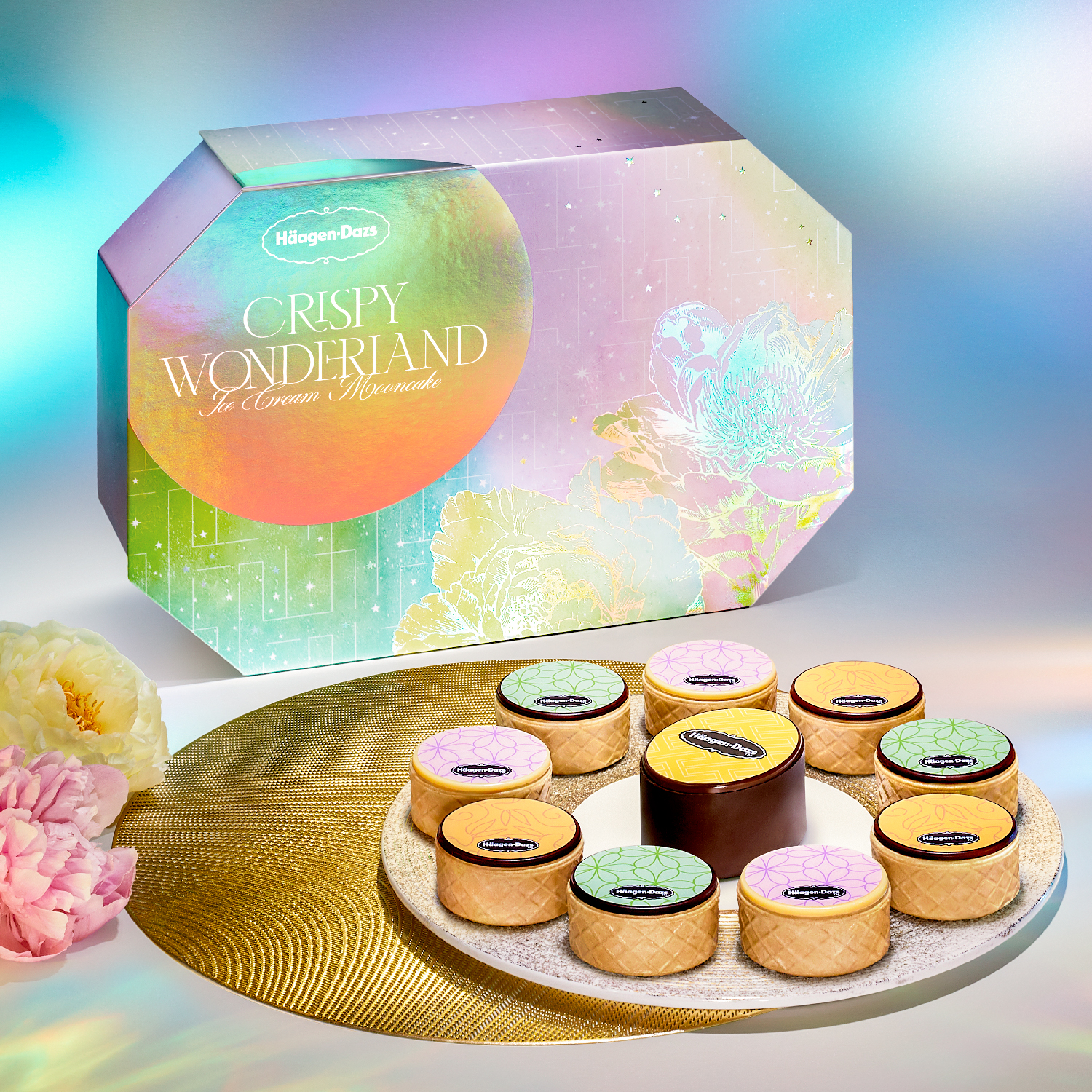 Häagen-Dazs' Crispy Wonderland ice cream gift box aside ten ice cream mooncakes neatly arranged in a circle on white and gold tray beside a floral bouquet.
